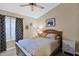 Comfortable bedroom features neutral tones, ceiling fan, stylish furniture, and natural light at 19107 N 94Th Ave, Peoria, AZ 85382