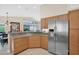 Bright kitchen features granite counters, wood cabinetry, and stainless steel refrigerator at 19107 N 94Th Ave, Peoria, AZ 85382