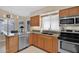 Well-lit kitchen featuring modern stainless steel appliances and tile floors at 19107 N 94Th Ave, Peoria, AZ 85382