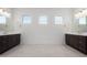Bathroom featuring dark wood vanities, double sinks, modern fixtures, and bright lighting at 20256 W Monterey Way, Buckeye, AZ 85396