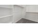 Walk-in closet with carpet and multiple white shelves and wooden hanger rods for storage and organization at 20256 W Monterey Way, Buckeye, AZ 85396