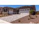A charming home featuring a two-car garage, paver driveway, and desert landscaping at 20256 W Monterey Way, Buckeye, AZ 85396