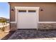 Exterior view of garage door with decorative lights and a patterned paver driveway at 20256 W Monterey Way, Buckeye, AZ 85396