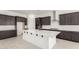 Modern kitchen featuring a large center island, dark wood cabinetry, and stainless steel appliances at 20256 W Monterey Way, Buckeye, AZ 85396