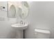 Stylish powder room with a pedestal sink, decorative mirror, and modern fixtures at 20256 W Monterey Way, Buckeye, AZ 85396