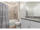 Bathroom features a tub shower combo, neutral tiling, and a gray countertop vanity at 20783 W Pasadena Ave, Buckeye, AZ 85396