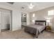 Neutral bedroom with carpet, fan, gray curtains, bedside tables, and a bed with gray bedding at 20783 W Pasadena Ave, Buckeye, AZ 85396