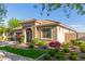 Attractive single-story home with a tile roof, stone facade, landscaping, and a lush green lawn, enhancing curb appeal at 20783 W Pasadena Ave, Buckeye, AZ 85396