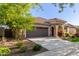Inviting home exterior with a tile roof, stone accents, lush landscaping, and a well-manicured lawn at 20783 W Pasadena Ave, Buckeye, AZ 85396