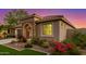 Well-maintained single-story home featuring manicured landscaping, a stone archway, and a cozy entrance at 20783 W Pasadena Ave, Buckeye, AZ 85396