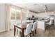 Open-concept kitchen and dining area with modern white cabinets, stainless steel appliances, and stylish lighting at 20783 W Pasadena Ave, Buckeye, AZ 85396