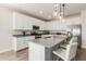Modern kitchen featuring white cabinets, stainless steel appliances, and a spacious center island with seating at 20783 W Pasadena Ave, Buckeye, AZ 85396