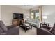 Comfortable living room with a sofa, armchairs, a television, and neutral tones at 20783 W Pasadena Ave, Buckeye, AZ 85396