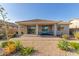 Relaxing covered patio with stylish seating and landscaped yard that offers a serene outdoor living space at 20783 W Pasadena Ave, Buckeye, AZ 85396