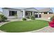 Lush backyard features artificial turf, decorative shrubs, and a covered patio ideal for outdoor enjoyment at 22964 E Via Del Sol --, Queen Creek, AZ 85142