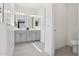 Bathroom featuring dual sinks, modern lighting, and a separate toilet room, showcasing a bright interior at 22964 E Via Del Sol --, Queen Creek, AZ 85142