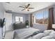 Staged bedroom with calming blue tones, ceiling fan, and picturesque window view at 22964 E Via Del Sol --, Queen Creek, AZ 85142