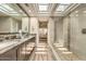 Bright bathroom with double vanity, granite countertops, large mirror, and glass-enclosed shower at 25555 N Windy Walk Dr # 69, Scottsdale, AZ 85255