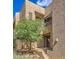 Attractive townhome exterior with desert landscaping, mature trees, and welcoming front entryway at 25555 N Windy Walk Dr # 69, Scottsdale, AZ 85255