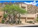 Attractive townhome exterior with desert landscaping, front yard tree, and attached two car garage at 25555 N Windy Walk Dr # 69, Scottsdale, AZ 85255