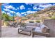 Inviting stone patio featuring a wicker sectional, lounge chairs, and stunning desert mountain views at 25555 N Windy Walk Dr # 69, Scottsdale, AZ 85255