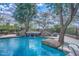Serene pool area features a waterfall feature surrounded by mature landscaping at 25555 N Windy Walk Dr # 69, Scottsdale, AZ 85255