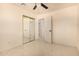 A bright bedroom with a ceiling fan, tile floors and mirrored closet doors at 2721 W Luke Ave, Phoenix, AZ 85017