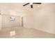 A bright, minimalist bedroom with tile flooring, ceiling fan, and window at 2721 W Luke Ave, Phoenix, AZ 85017