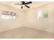 A clean bedroom with tile floors, ceiling fan, and two windows at 2721 W Luke Ave, Phoenix, AZ 85017