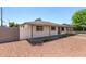 Single-story home with covered patio, minimal landscaping, and white painted brick at 2721 W Luke Ave, Phoenix, AZ 85017