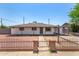 Charming single-story home with red rock front yard and brick and iron fence at 2721 W Luke Ave, Phoenix, AZ 85017