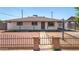 Quaint single-story house featuring a gated yard with red rock landscaping at 2721 W Luke Ave, Phoenix, AZ 85017