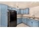 This kitchen features blue cabinets and modern black appliances at 2721 W Luke Ave, Phoenix, AZ 85017
