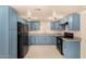 This kitchen features blue cabinets, modern appliances, and a bright, airy feel at 2721 W Luke Ave, Phoenix, AZ 85017
