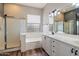 Well-lit bathroom with vanity, shower stall, and a separate bathtub at 2761 W Via Calabria --, Phoenix, AZ 85086
