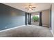 Spacious bedroom with neutral carpet, fan and a large window with tree view at 2761 W Via Calabria --, Phoenix, AZ 85086