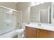 Bathroom features a shower-tub combination with glass doors, toilet, and vanity with sink at 29356 N 67Th Ave, Peoria, AZ 85383