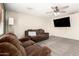 Inviting living room featuring neutral carpet, fan, and a mounted television for entertainment at 3049 W Santa Cruz Ave, San Tan Valley, AZ 85144