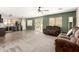 Inviting living room featuring neutral carpet, fan, and a mounted television for entertainment at 3049 W Santa Cruz Ave, San Tan Valley, AZ 85144