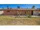 Backyard showcasing a brick house, a grassy lawn, and some desert landscaping under a clear sky at 3644 W Maryland Ave, Phoenix, AZ 85019
