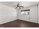 Bedroom showcasing dark wood floors, a ceiling fan with lights, and a window for natural light at 3644 W Maryland Ave, Phoenix, AZ 85019