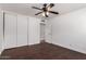 Bedroom with dark floors, ceiling fan, double closet and hallway access at 3644 W Maryland Ave, Phoenix, AZ 85019