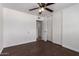 Bedroom boasts dark floors, a ceiling fan, double closet, and hallway access at 3644 W Maryland Ave, Phoenix, AZ 85019