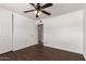 Bedroom featuring a ceiling fan, hardwood floors, a closet, and a door leading to another room at 3644 W Maryland Ave, Phoenix, AZ 85019