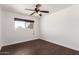 Bedroom features dark wood-style floors, a window with natural light, and a ceiling fan at 3644 W Maryland Ave, Phoenix, AZ 85019