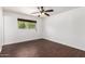 Bedroom boasts dark wood floors, neutral walls, ceiling fan, and a bright window at 3644 W Maryland Ave, Phoenix, AZ 85019
