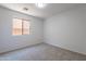 Empty carpeted bedroom with a window providing natural light at 37053 W Amalfi Ave, Maricopa, AZ 85138