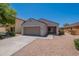 Single-story home featuring a two-car garage, desert landscaping, and a well-maintained front yard at 37053 W Amalfi Ave, Maricopa, AZ 85138