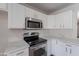 Modern kitchen with stainless steel appliances and white cabinets at 37053 W Amalfi Ave, Maricopa, AZ 85138