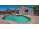 Backyard pool and patio with desert landscaping and a clear blue sky at 37053 W Amalfi Ave, Maricopa, AZ 85138
